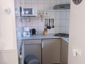 Il comprend une petite cuisine équipée d'une cuisinière et d'un four micro-ondes. dans l'établissement Brugman, à Egmond aan Zee