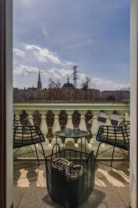 a patio with chairs and a table with a view of a city at Riverside Hotel Plzeň in Pilsen