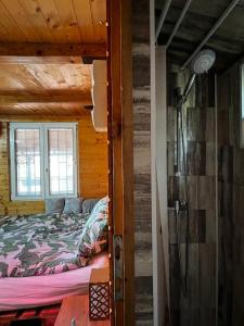 ein Schlafzimmer mit einem Bett in einem Holzhaus in der Unterkunft Kuca i splav na reci Savi in Belgrad