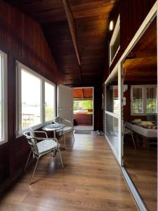 a room with chairs and a table and windows at Sojenica Zaton - Stilt House in Belgrade