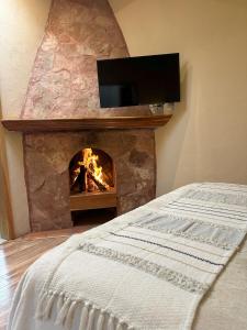 a bedroom with a fireplace with a tv above it at Cabañas Rancho El Mayab in Zacatlán