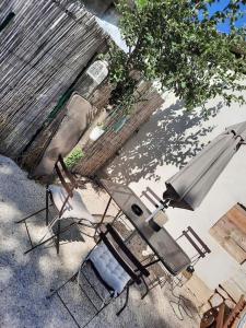 un patio al aire libre con sillas y sombrilla en adorable guest house avec jardin et parking privatif, en Aix-en-Provence