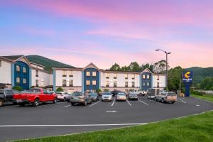 un aparcamiento con coches estacionados frente a los edificios en Comfort Inn Asheville East-Blue Ridge Pkwy Access, en Asheville