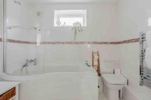 uma casa de banho branca com uma banheira e um WC em Lovely cosy annex by the sea em Bournemouth