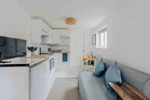uma sala de estar com um sofá e uma cozinha em Lovely cosy annex by the sea em Bournemouth