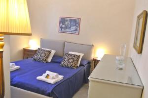 een kleine slaapkamer met een blauw bed met 2 kussens bij Gramsci Home in Volterra