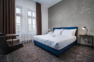 a bedroom with a large bed with a blue headboard at Riverside Hotel Plzeň in Plzeň