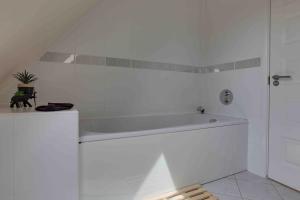 a white bath tub in a white bathroom at Elizabeth II Five Bedroom Spacious Home 