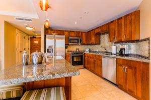 a kitchen with wooden cabinets and a counter top at Honua Kai H237 in Kaanapali Airport +29 photos