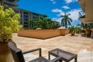 a patio with chairs and tables on a building at Honua Kai H237 in Lahaina