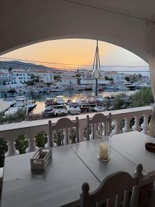 een tafel op een balkon met uitzicht op een haven bij Anezo's Exceptional View in Spetses
