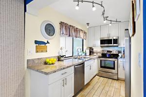 een keuken met witte kasten en roestvrijstalen apparaten bij Hale Ono Loa 117 in Kahana