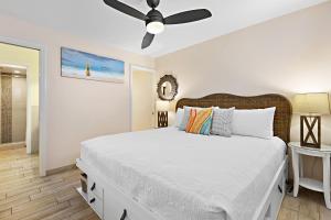 een slaapkamer met een bed en een plafondventilator bij Hale Ono Loa 117 in Kahana +16 foto's