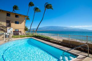 a swimming pool with a view of the beach at Hono Kai C10 in Maalaea