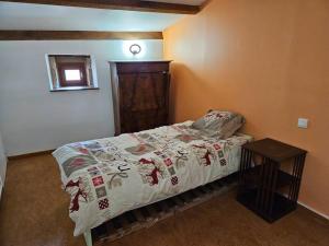 ein kleines Schlafzimmer mit einem Bett und einem Tisch in der Unterkunft Appartement Malleval Chez Jeanne in Malleval