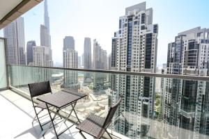 a balcony with a table and two chairs and a city at Luxury Apartment burj khalifa view in Dubai