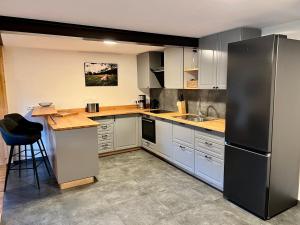 a kitchen with white cabinets and a black refrigerator at Beim Mühltaler II in Schleching