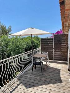 a table and chair with an umbrella on a deck at Grand Studio & Terrasse Privée in Hyères