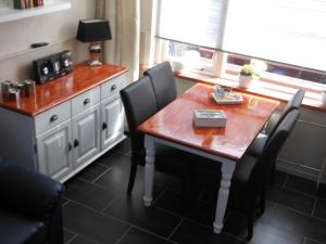 une cuisine avec une table en bois, des chaises et un comptoir dans l'établissement Brugman, à Egmond aan Zee