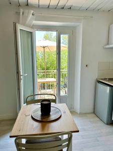 a coffee cup sitting on a wooden table in a kitchen at Grand Studio & Terrasse Privée in Hyères +3 photos