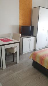 een kamer met een bureau, een tafel en een bed bij Apartmani Borko 3-1 in Loznica