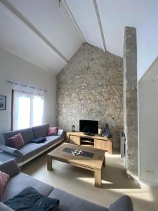 a living room with a couch and a table at Maison cosy proche centre ville in Compiègne