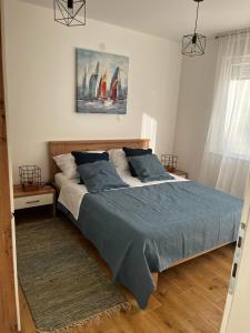 a bedroom with a large bed with blue blankets and pillows at Apartman Mila in Biograd na Moru