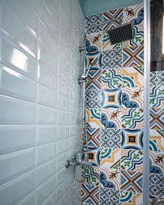 een douche in de badkamer met mozaïektegels bij One Salonica Deluxe Apartment 1 in Thessaloniki