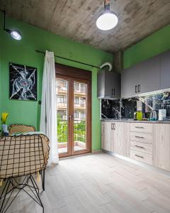 een keuken met groene muren en houten kasten bij One Salonica Deluxe Apartment 1 in Thessaloniki