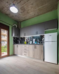 een keuken met houten kasten en een witte koelkast bij One Salonica Deluxe Apartment 1 in Thessaloniki