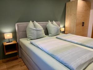 1 dormitorio con 2 camas y almohadas blancas en Beim Mühltaler II en Schleching