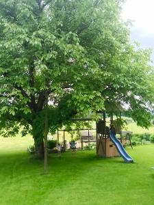 un parque infantil con un árbol y un tobogán en Ferienwohnungen Aumayr, en Gutau