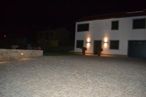 a large driveway in front of a white house at night at Casa Patricia in Pontevedra