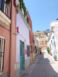 un callejón estrecho con edificios coloridos y una puerta azul en Casa Violette en Almería