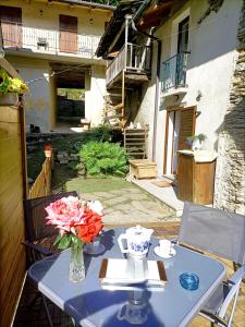 a table with a vase of flowers on it at La casetta delle bambole. in Massello