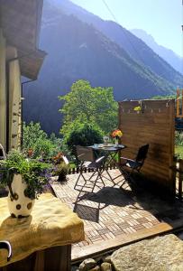 un patio con mesa y sillas y vistas a la montaña en La casetta delle bambole. en Massello