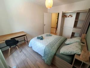 ein kleines Schlafzimmer mit einem Bett und einem Schreibtisch in der Unterkunft Joli cocon en hyper centre in Loudéac