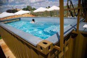 a person swimming in a swimming pool with at Habitaciones Casa Rural El Sauce in Nohales