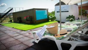 a patio with lawn chairs and a screen on a house at Habitaciones Casa Rural El Sauce in Nohales