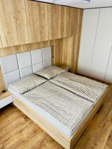 a large bed in a room with wooden floors at Urban PORT apartment in Liptovský Mikuláš