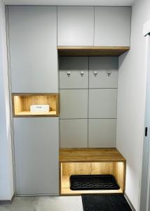 a kitchen with white walls and wooden shelves at Urban PORT apartment in Liptovský Mikuláš