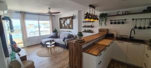a kitchen and living room with a couch and a table at Sunsetmare Vacational Apartment in Roses