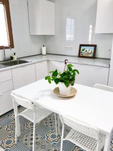 GüimeにあるCasa Güime, Apartment in a private houseの白いテーブルと椅子のある白いキッチン