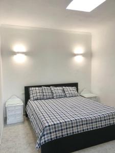 GüimeにあるCasa Güime, Apartment in a private houseのベッドルーム1室(チェック入りの毛布付きのベッド1台付)