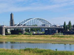 uma ponte sobre uma massa de água com uma torre de relógio em Medina B&B hartje Arnhem em Arnhem