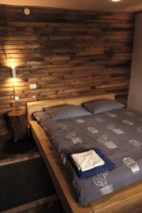 a large bed in a room with a wooden wall at EcoXata in Slavske