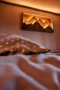 a bed with a picture of mountains on the wall at EcoXata in Slavske