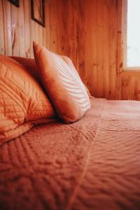 a bed with two pillows on top of it at Cabañas Huilipan in Las Trancas