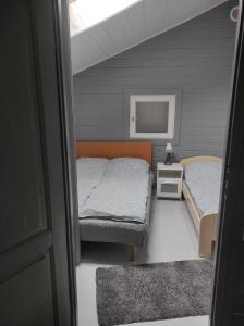 a small bedroom with two beds and a mirror at Domki Jagoda in Dębki