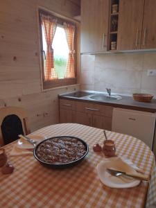 a kitchen with a table with a pizza on it at Brvnara Srna Zlatar in Nova Varoš